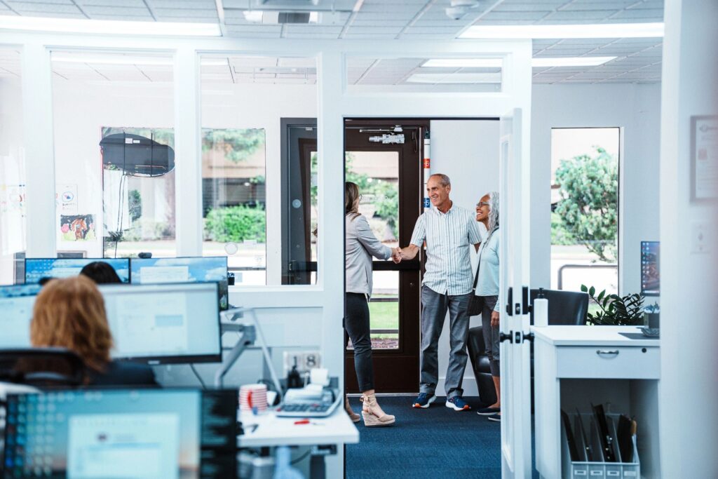 Bank employee greeting senior clients with handshake